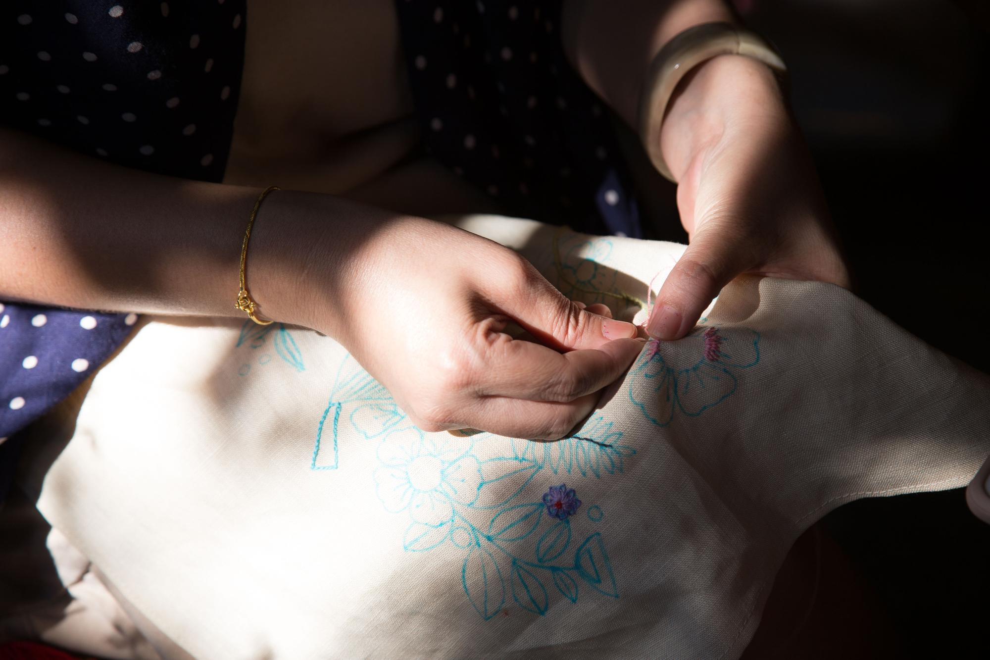 Artisan hands embroidering a simple motif